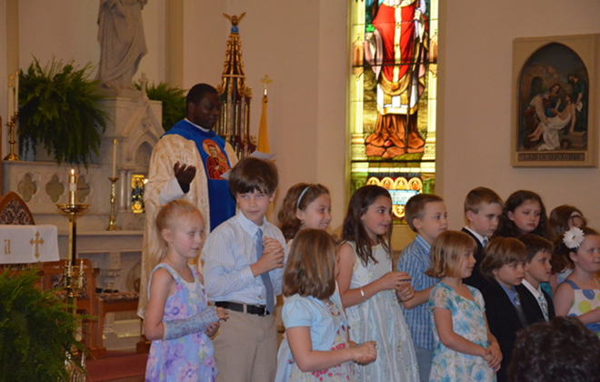 Young members of the parish recite the Litany of Our Lady during the crowning of the Blessed Mother's statue in May.