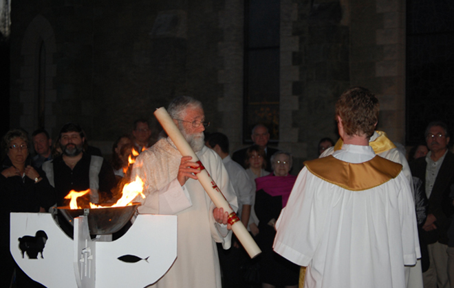 In the courtyard Deacon James Kledzik holds the paschal candle during the blessing of the new fire at the Easter Vigil.