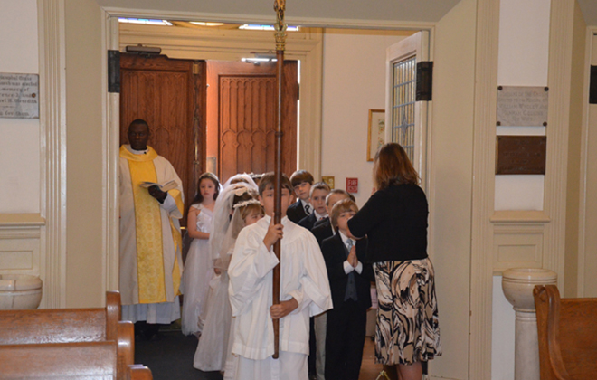 Children of the parish walk in procession for the Mass at which they will receive their first communion.