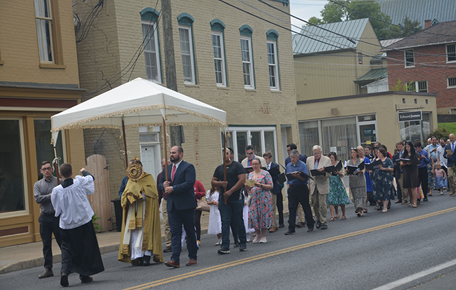 On the feast of the Body and Blood of Christ, parishioners participate in an outdooe procession.