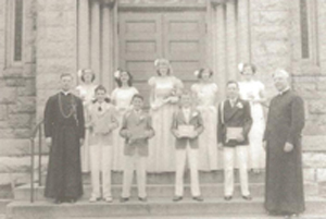 Father Donfred H. Stockert, left, and a graduating class with Father James Gacquin