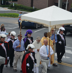 In addition to their charitable works, the Knights of Columbus here act as a color guard in the Corpus Christi procession.